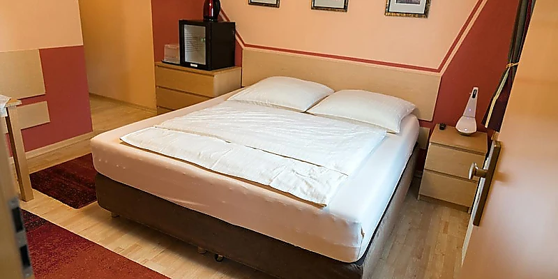 Doppelzimmer mit großem Doppelbett und gemütlicher Einrichtung.
