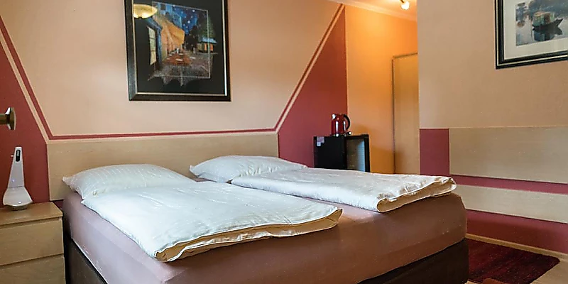 Hotelzimmer mit Doppelbett und gemütlicher Einrichtung.