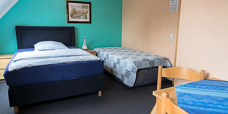 Zweibettzimmer mit zwei Einzelbetten und Sitzecke.